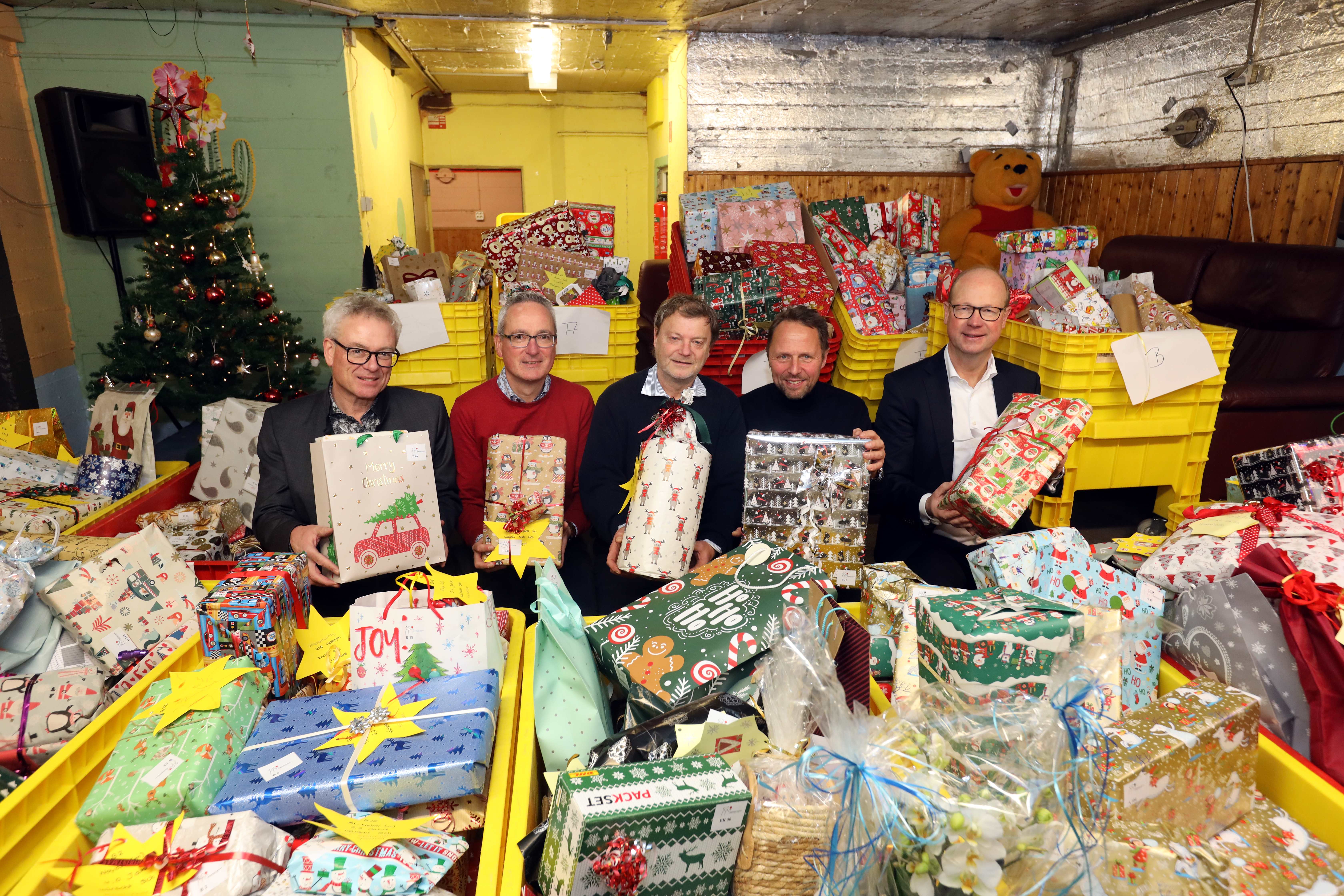 Das Bild zeigt inmitten eines Teils der über 900 Geschenke (von links nach rechts): Klaus Niesen (Geschäftsführer der Peter Niesen GmbH & Co. Internationale Möbelspedition KG), Markus Kalcker (Prokurist der Peter Niesen GmbH & Co. Internationale Möbelspedition KG), Reiner Hilken (Netzwerk Kinderarmut), Uwe Richrath (stv. Vorsitzender des Stiftungsvorstandes) und Markus Grawe (Vorsitzender des Stiftungsvorstandes)